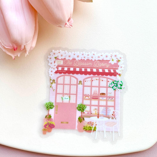 Sticker of a bakery design on a white surface with pink flowers.
