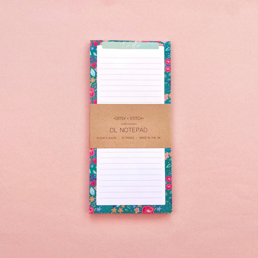 Floral notepad with a brown kraft paper cover on a pink background
