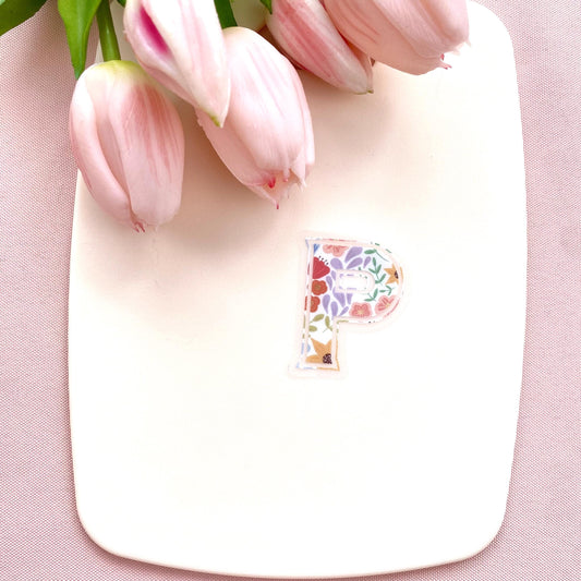 Floral letter 'P' sticker on a cream background with pink tulips.
