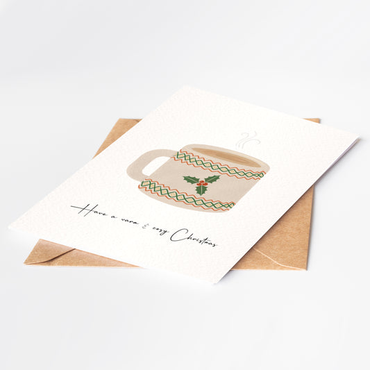 Greeting card with a Christmas-themed teacup design and envelope on a white background