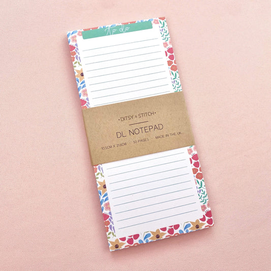 Floral bordered and lined slim notepad on a pink background