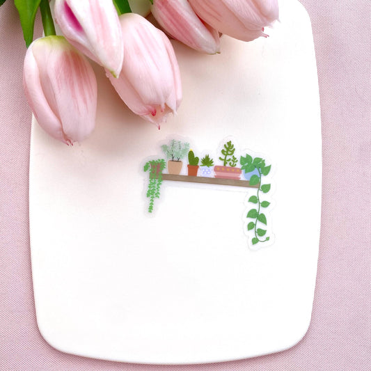 A transparent vinyl sticker with an illustration of a wooden shelf with potted plants on a white background