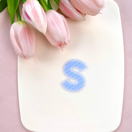 Blue striped letter 'S' transparent sticker on a white background with pink tulips
