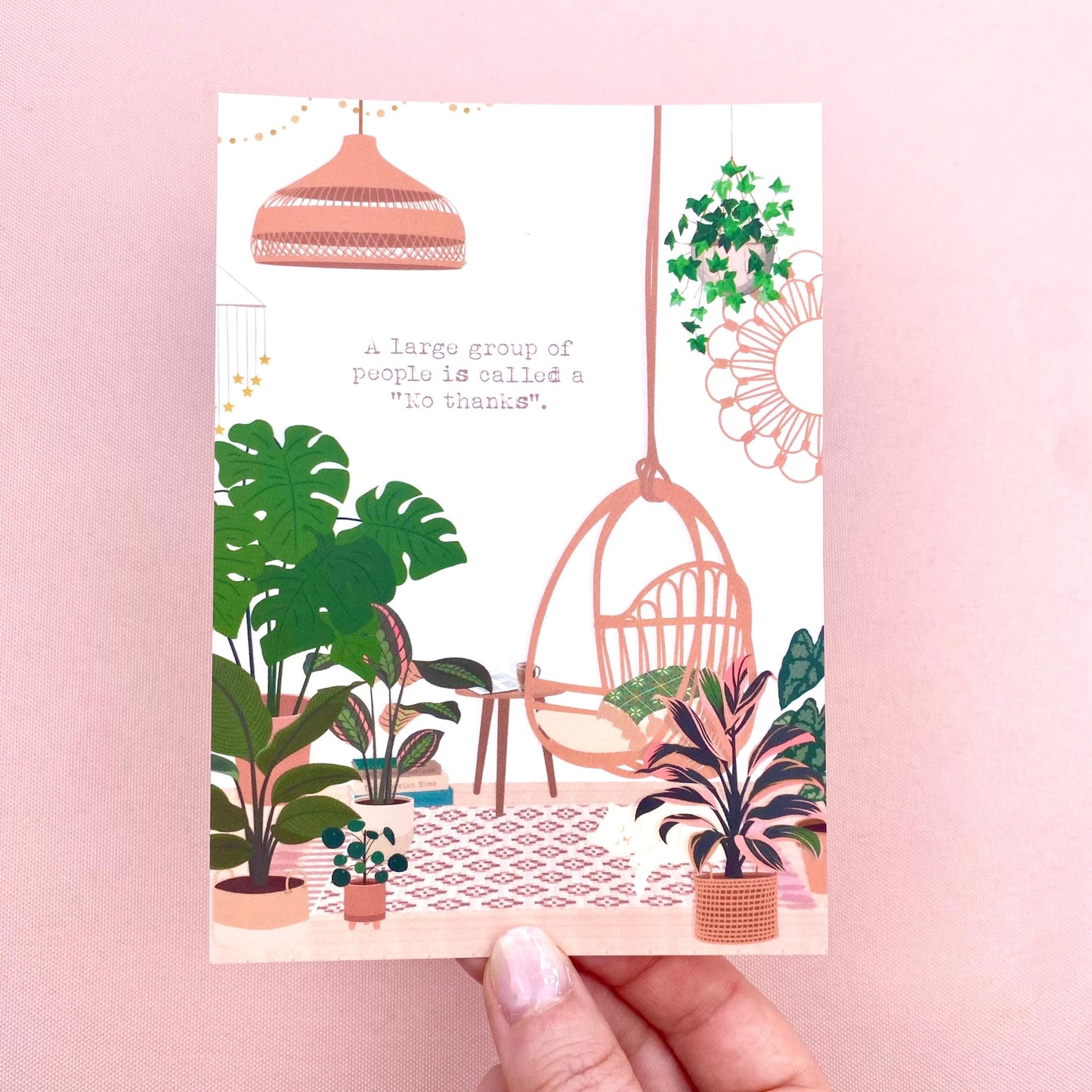 Postcard with a design of plants, a hanging chair, and a lamp on a pink background.