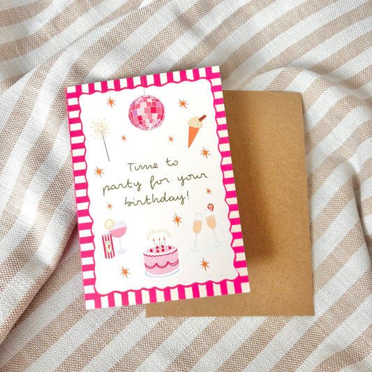 Birthday card with pink and white striped border and party illustrations on a textured fabric background