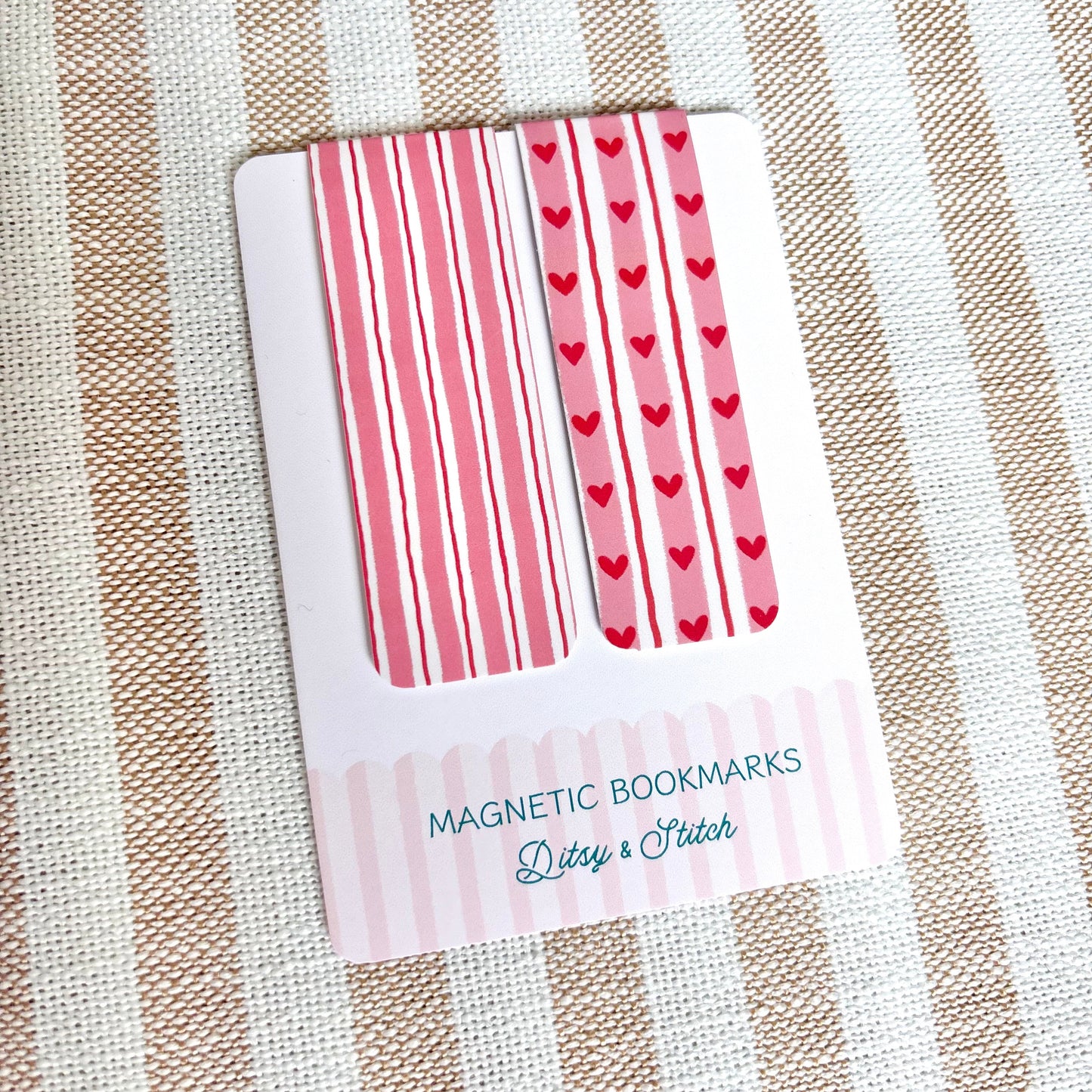 Pack of magnetic bookmarks with heart and striped patterns on a striped fabric background