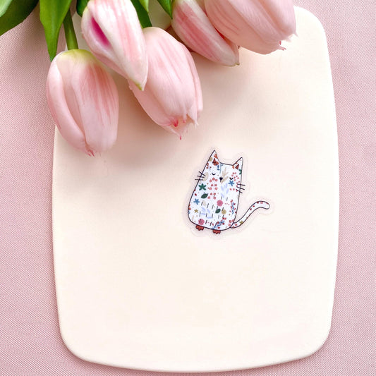 White board with a cat illustration sticker and pink tulips on a pink background