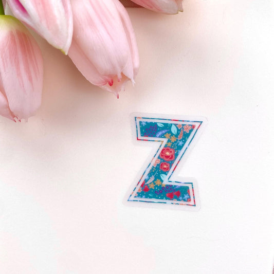 Floral letter 'Z' sticker on a light pink background with pink tulips