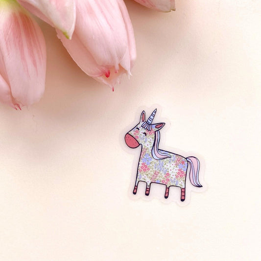 Floral unicorn sticker on a light pink background with pink tulips