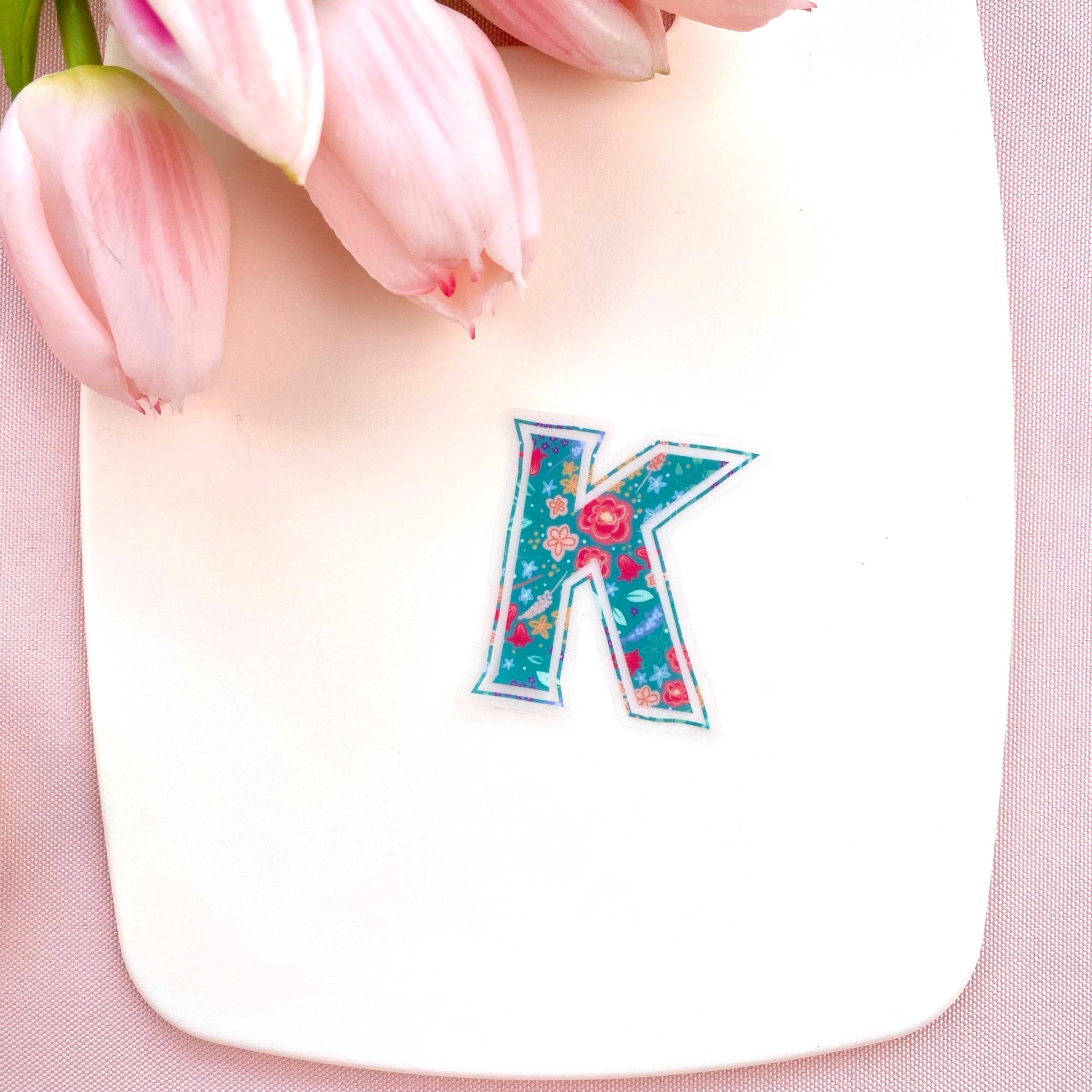 Floral letter 'K' sticker on a white background with pink tulips.