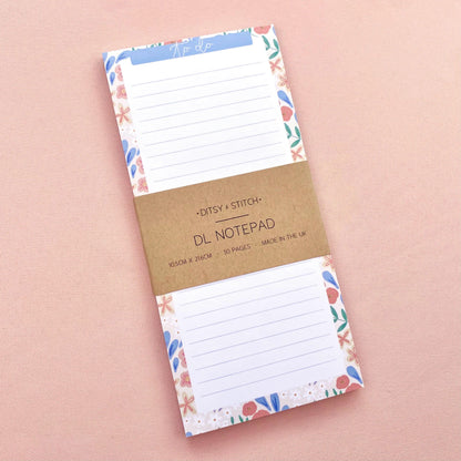 Floral bordered and lined slim notepad on a pink background
