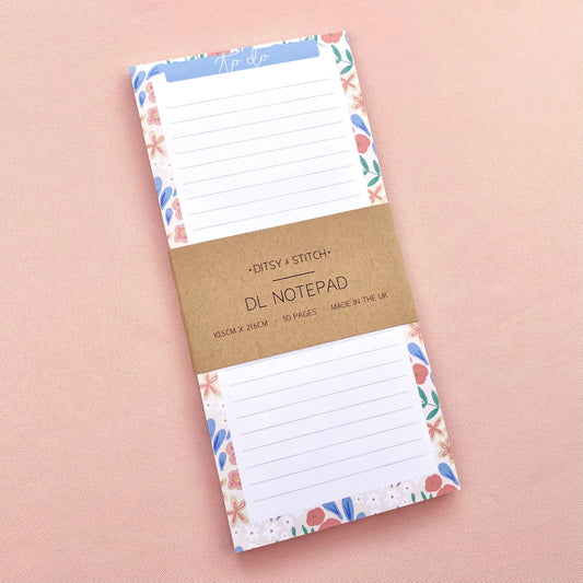 Floral bordered and lined slim notepad on a pink background