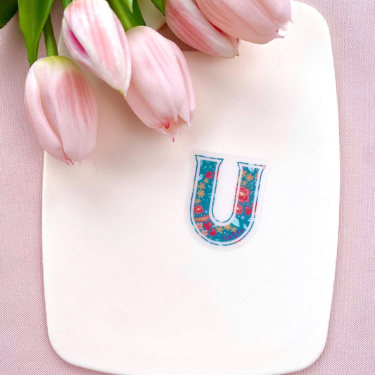 Decorative letter 'U' sticker with floral pattern on a white background