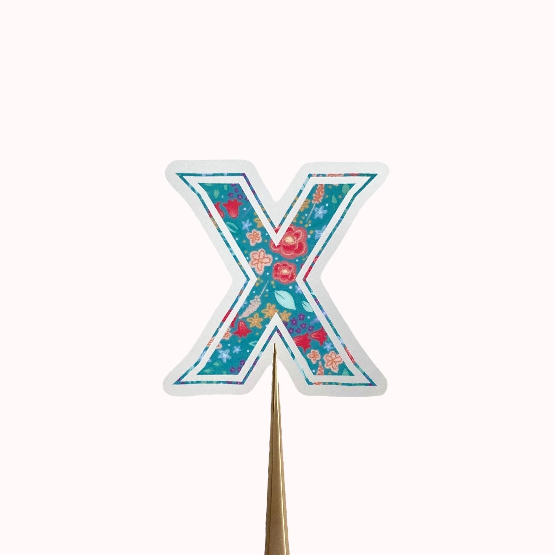 Floral letter 'X' sticker on a light background