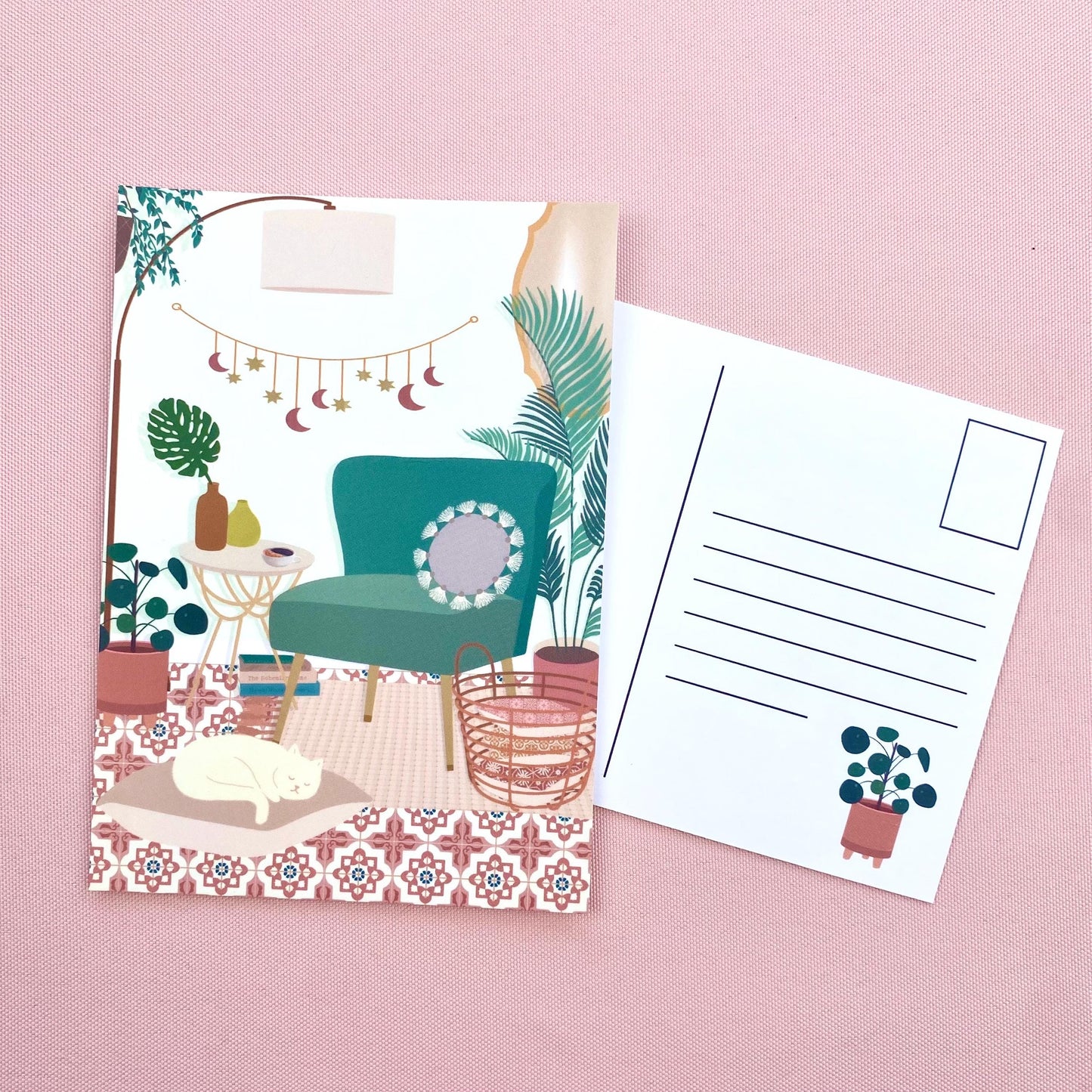 Illustrated postcard with a teal chair and plants on a pink background