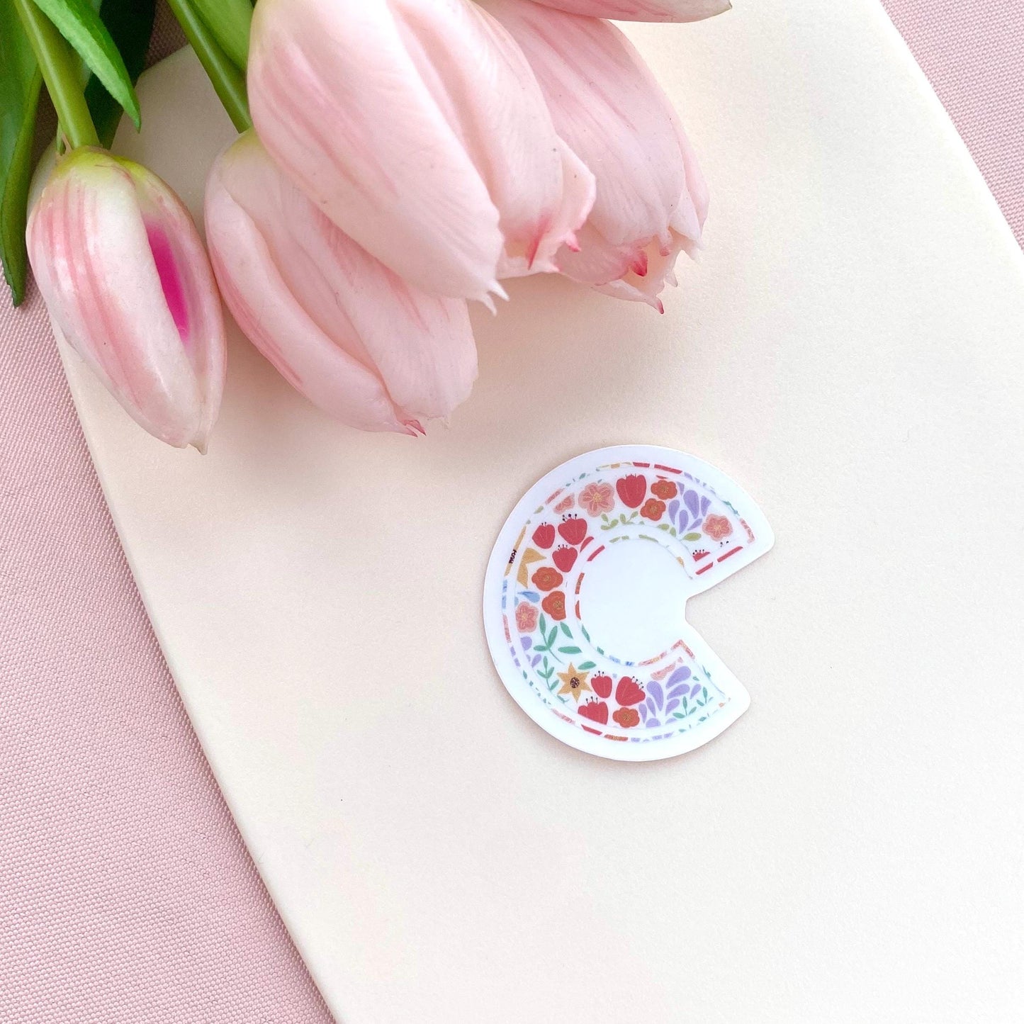 Sticker with letter 'C' with floral pattern on a white background with pink tulips