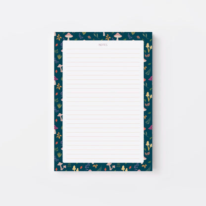 Lined notepad with a decorative blue border featuring mushrooms and leaves on a white background