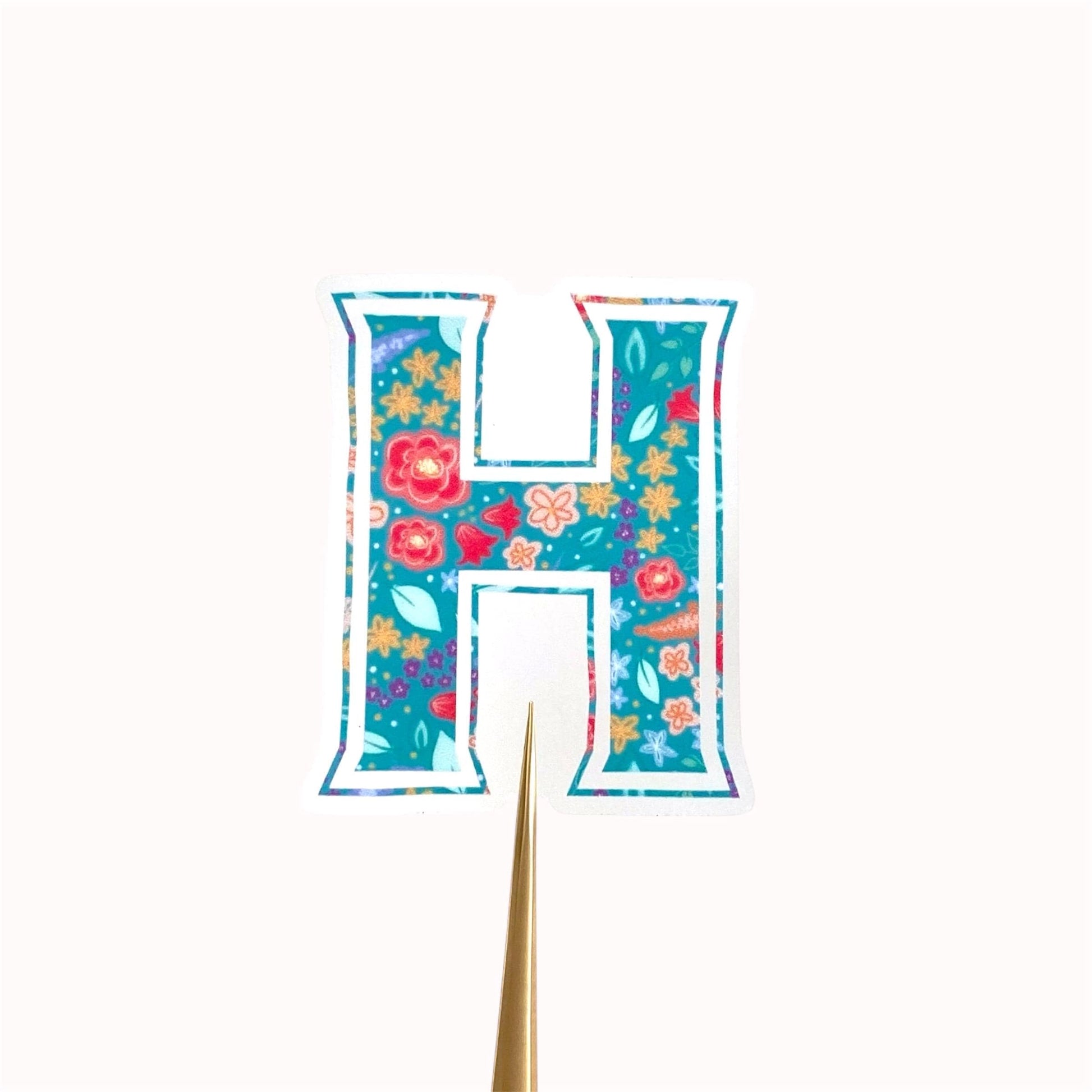 Letter 'H' shaped sticker with floral design on a white background