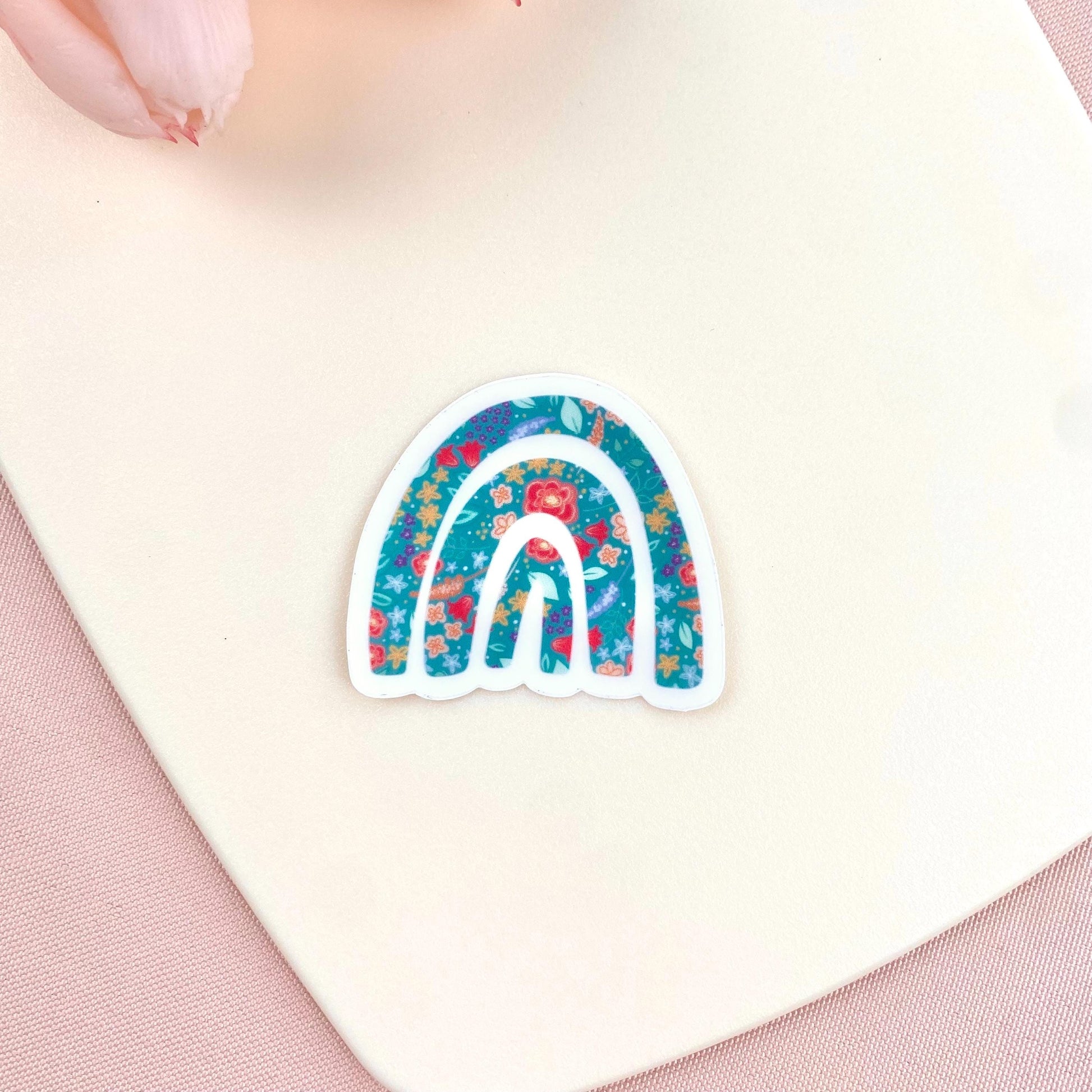 Decorative sticker with a floral rainbow design on a white surface.