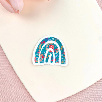 Decorative sticker with a floral rainbow design on a white surface.