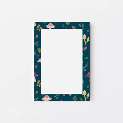 Notepad with mushroom and leaf patterned border on a white background