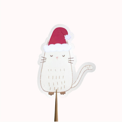 White cat-shaped sticker with a red hat on a white background