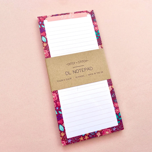 Floral-patterned slim notepad with a pink border on a white background
