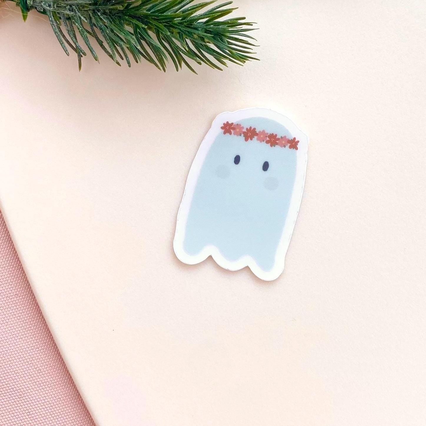 Sticker of a ghost with a floral headband on a light pink background
