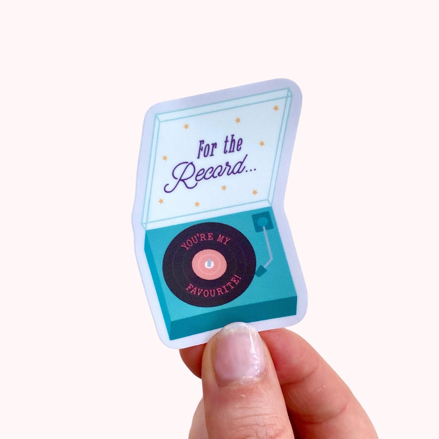 Sticker with a record player design held by a hand on a white background