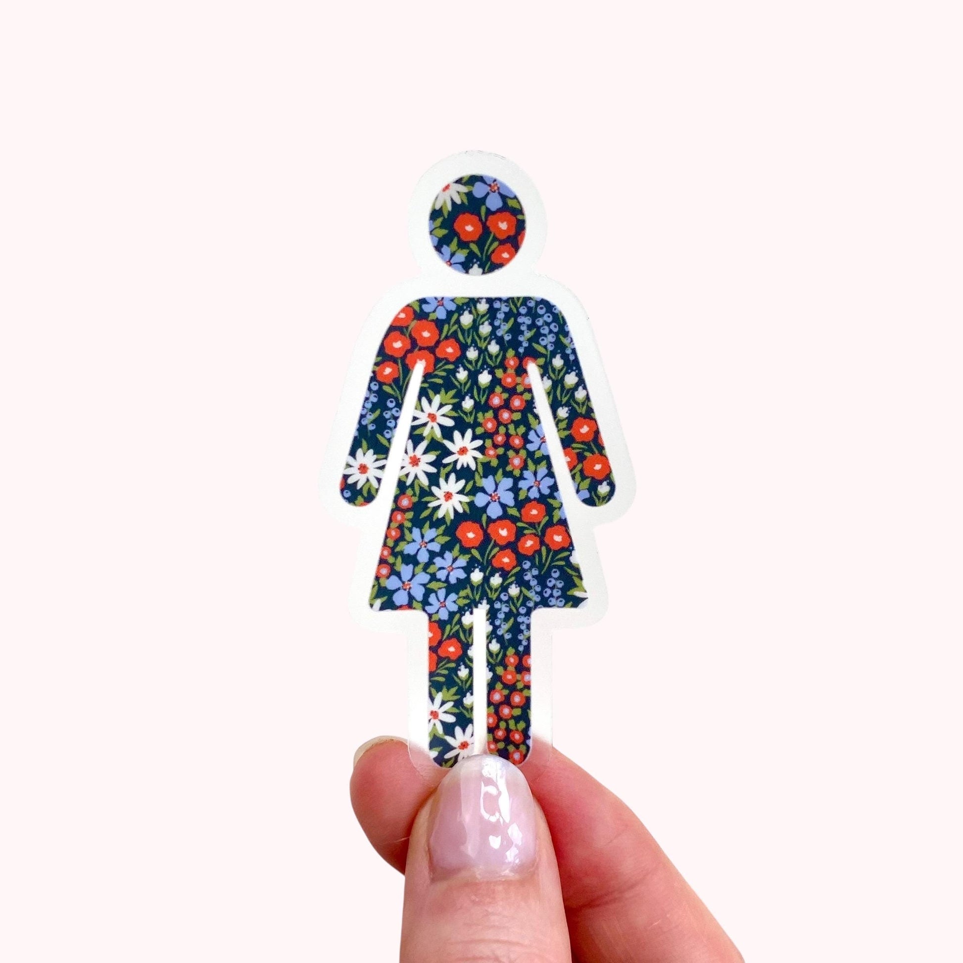 Transparent sticker with floral-patterned woman figure held by a hand on a white background