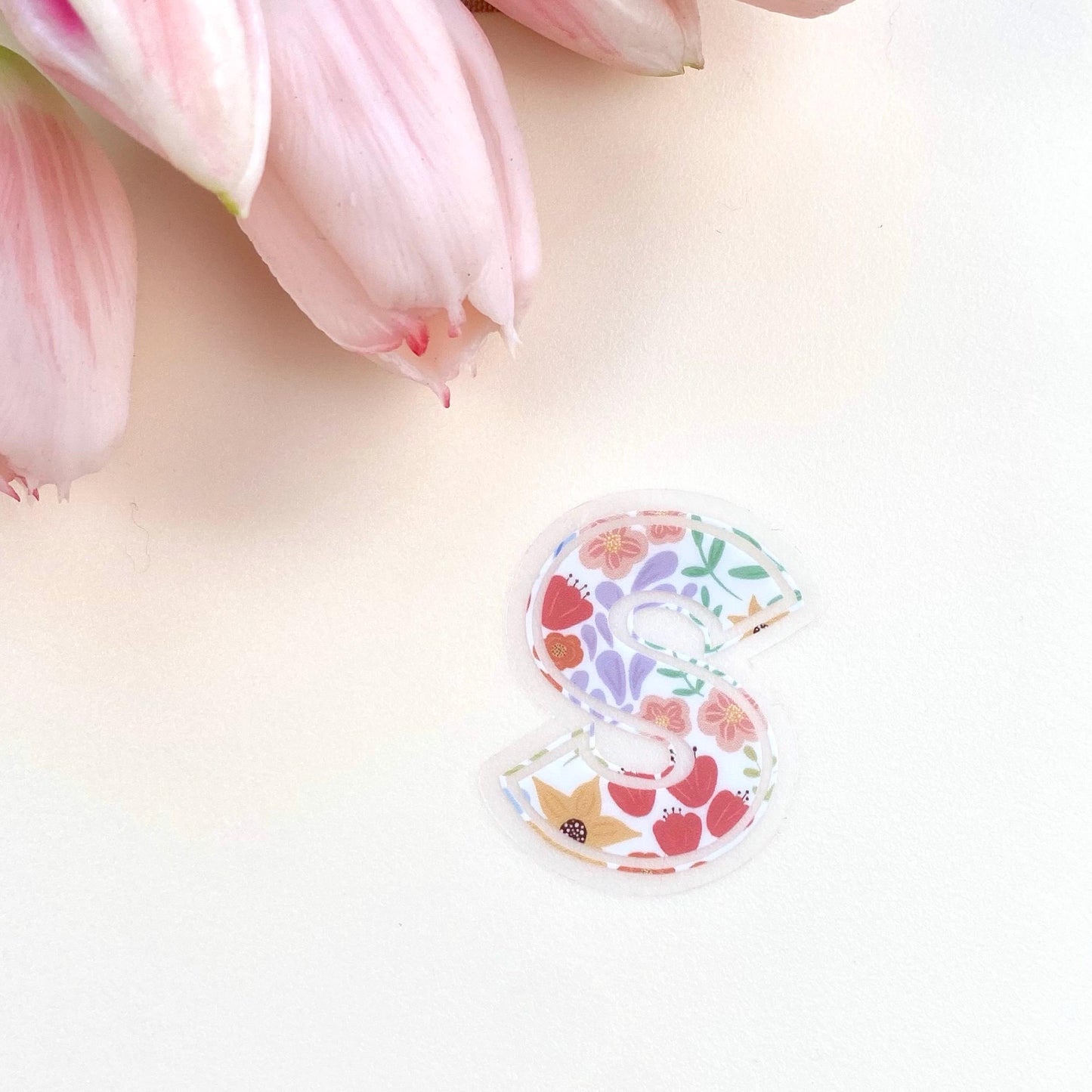 Decorative letter 'S' sticker with floral pattern on a white background