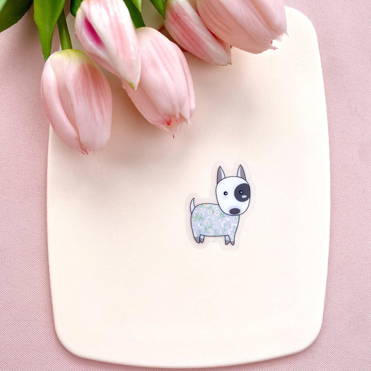 Sticker with a dog illustration on a pink surface with pink tulips.