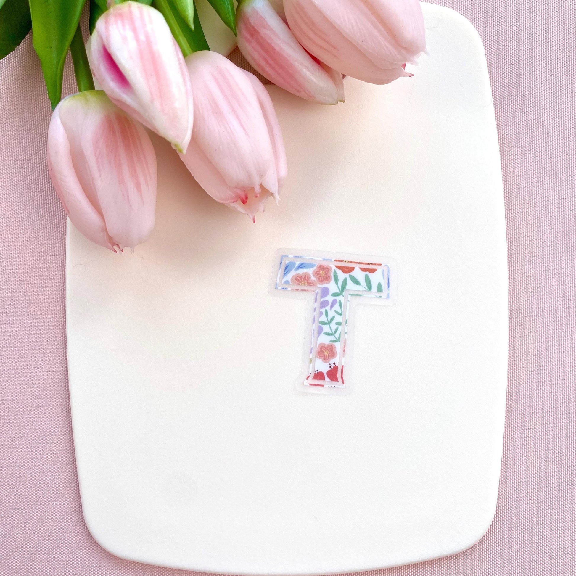 Floral letter 'T' sticker on a white background with pink tulips.