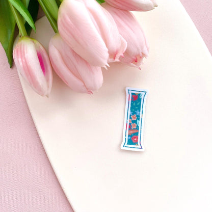 Clear vinyl sticker with a teal floral patterned letter 'I' shown on a white background with pink tulips