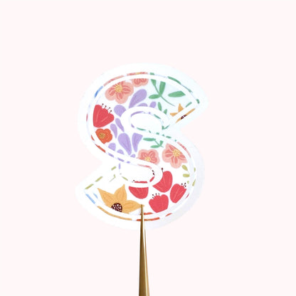 Decorative letter 'S' sticker with floral pattern on a white background
