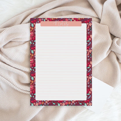 Floral-patterned notepad on a textured fabric background
