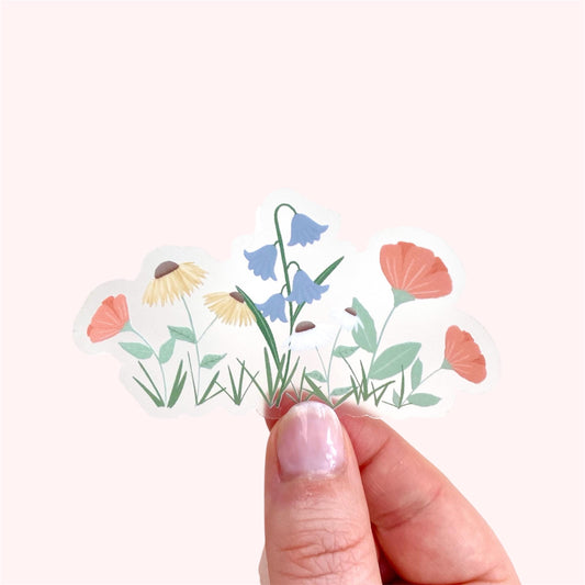 Hand holding a sticker with colourful garden flowers design on a white background