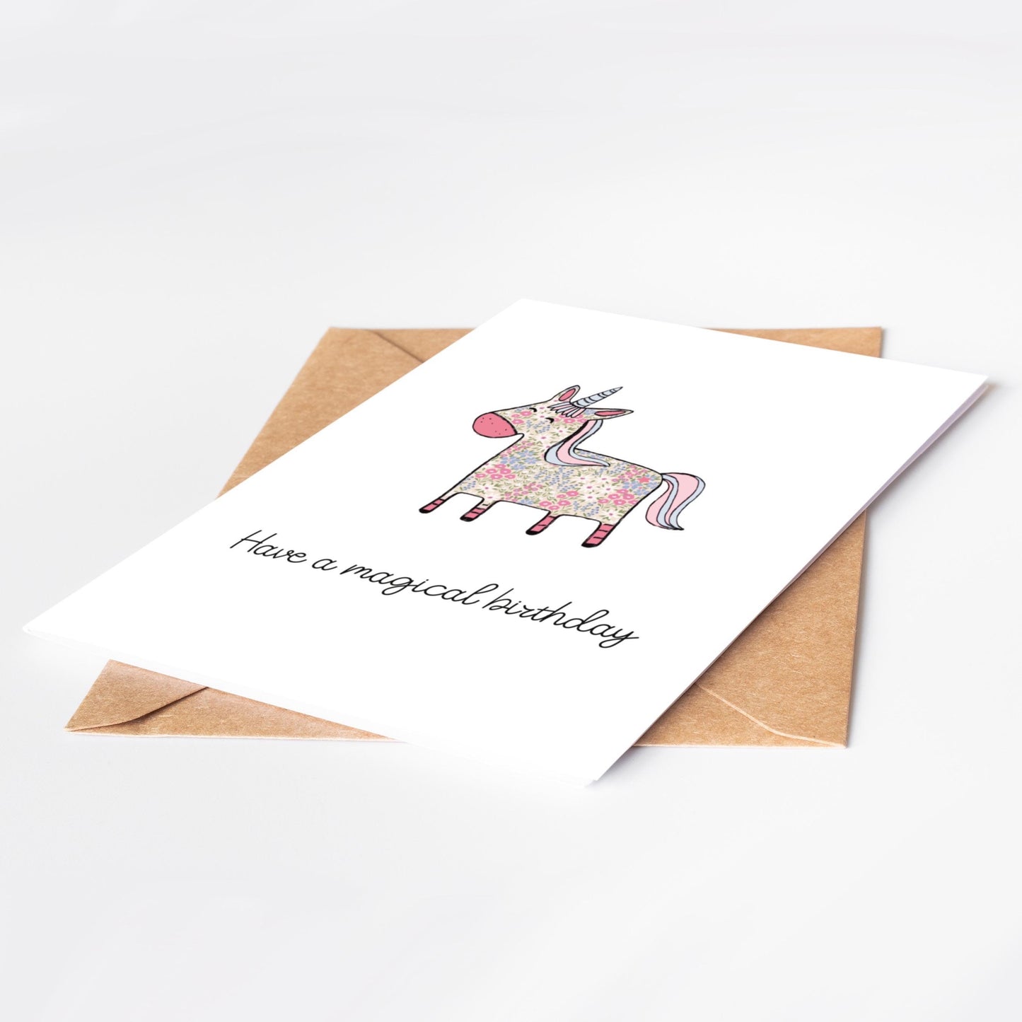 Greeting card with unicorn illustration and 'Have a magical birthday' text on a white background.