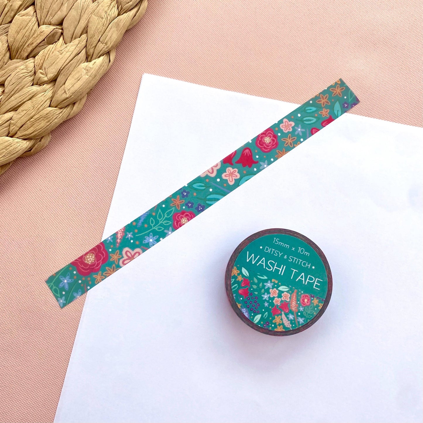 Floral-patterned washi tape with a roll on a white surface