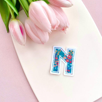 Floral letter 'N' sticker on a cream background with pink tulips