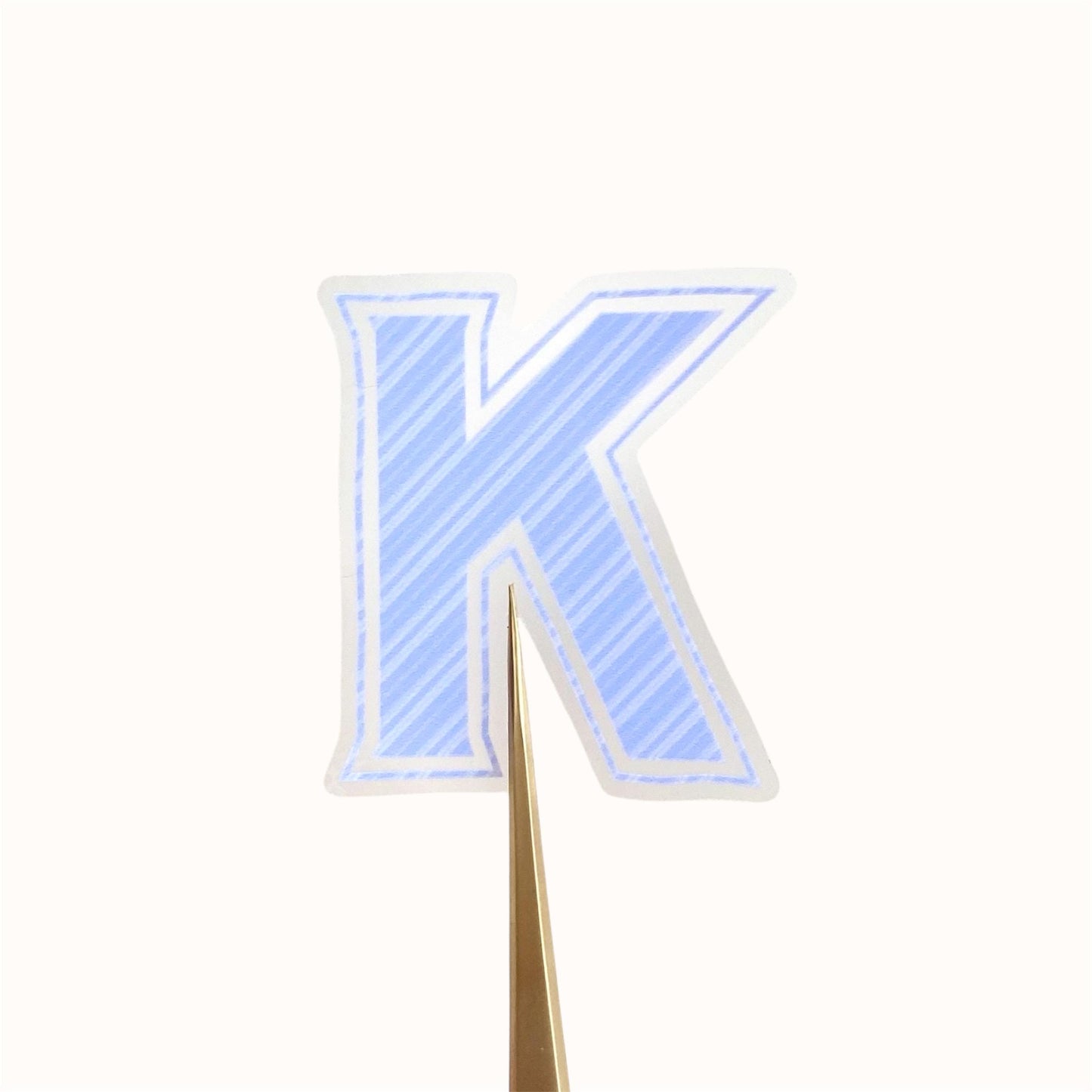 Blue striped letter 'K' transparent sticker against a white background