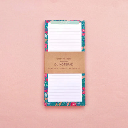 Floral notepad with a brown kraft paper cover on a pink background