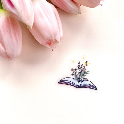 Decorative sticker of an open book with floral designs on a white background