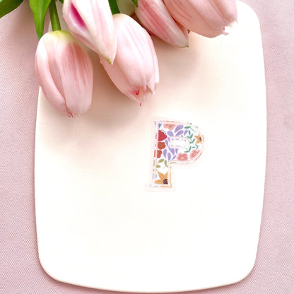 Floral letter 'P' sticker on a cream background with pink tulips.