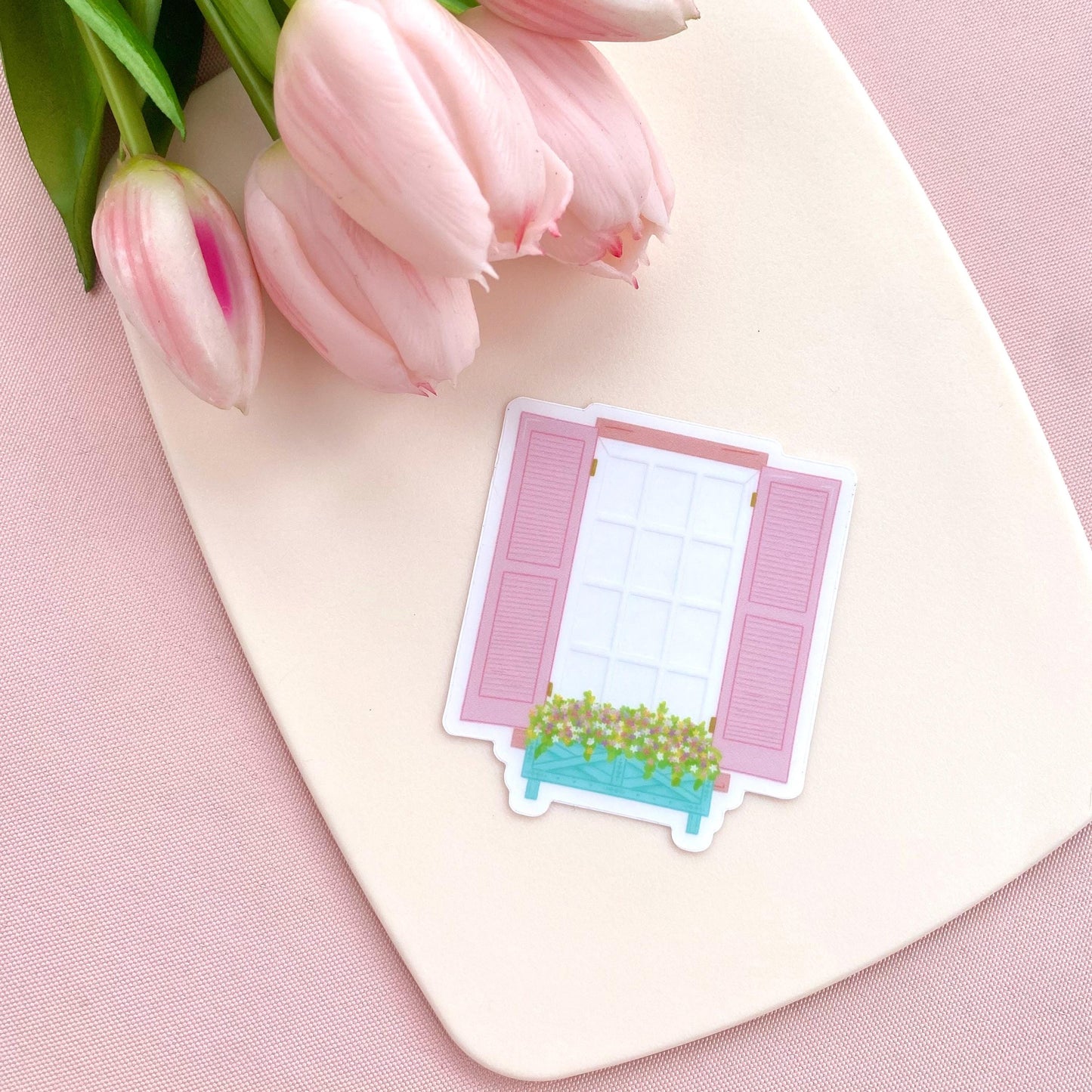 Transparent sticker of a window with pink shutters and a flower box on a white background