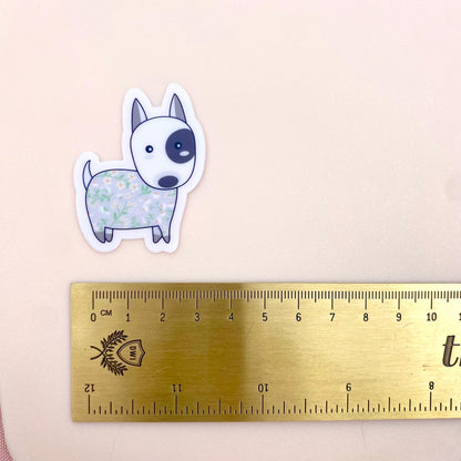 Sticker of a dog with floral pattern next to a ruler on a beige background