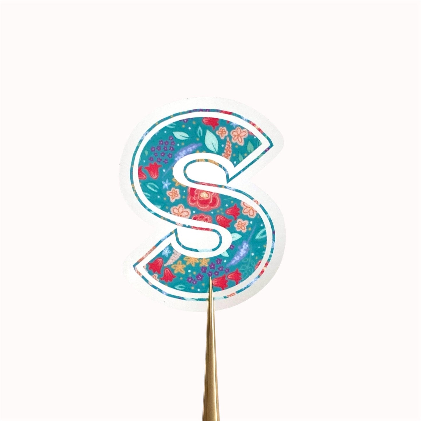 Decorative letter 'S' sticker with floral pattern on a white background