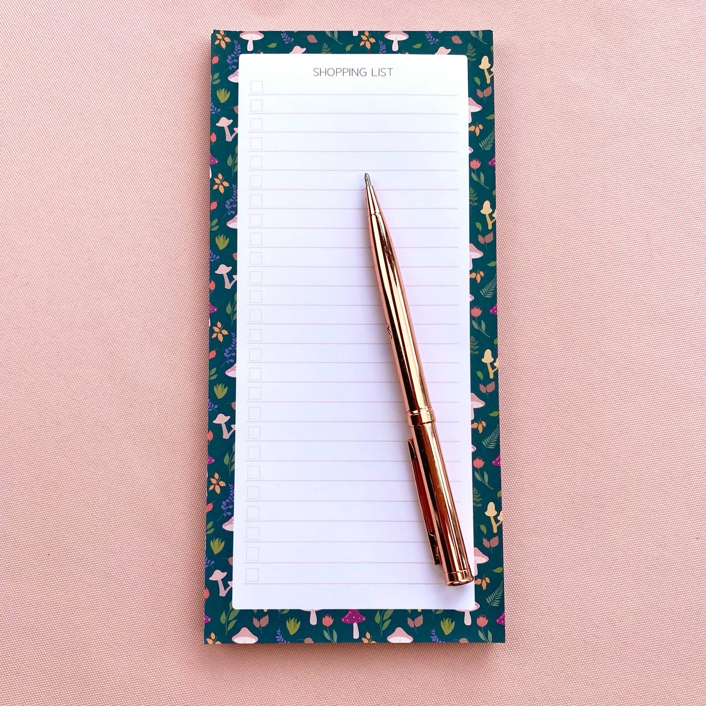 Autumn foliage-patterned shopping list notepad on a pink background