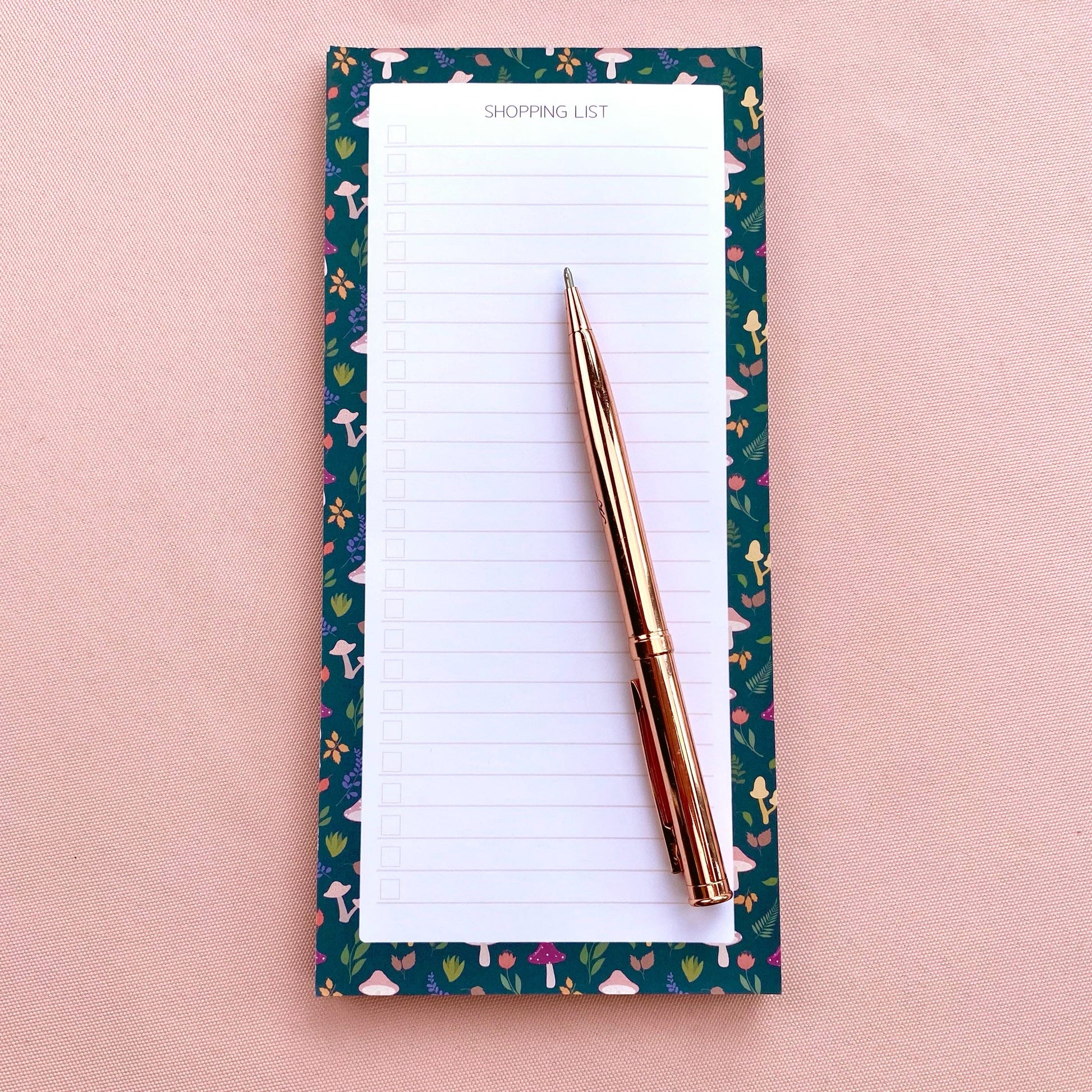 Autumn foliage-patterned shopping list notepad on a pink background