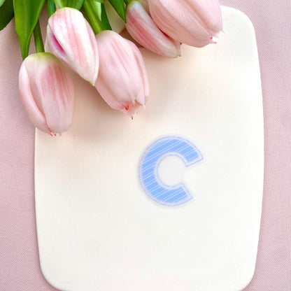 Blue striped  letter 'C' transparent sticker on a white background with pink tulips